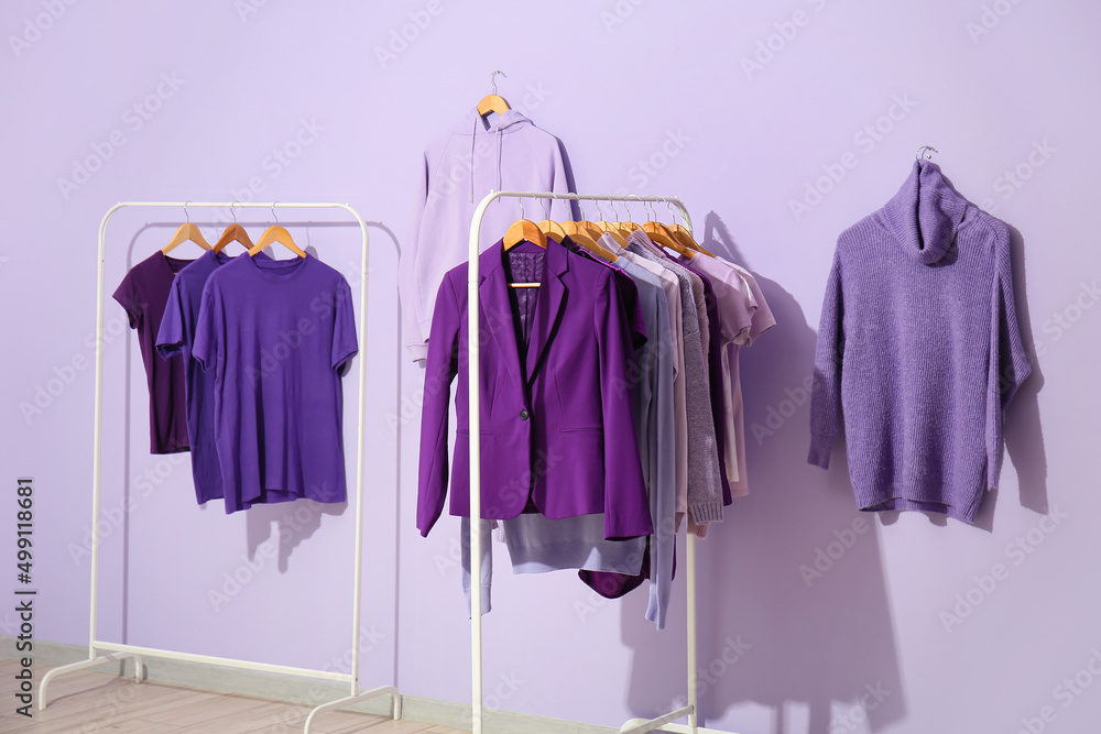 淡紫色墙壁附近的架子上放着紫色的衣服