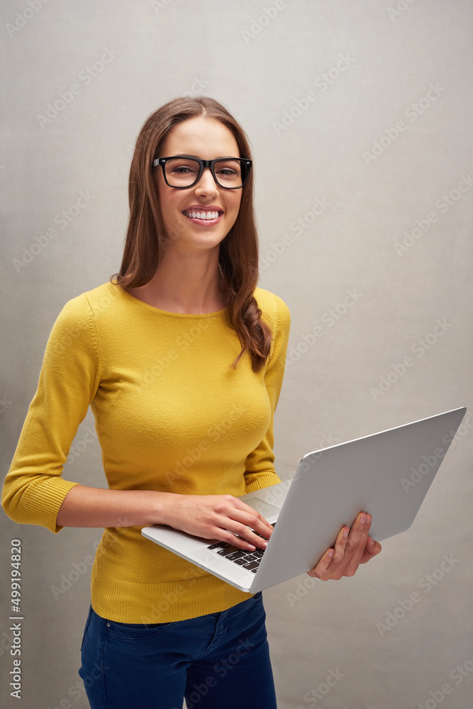 我总是联系在一起。一位有魅力的年轻女子的工作室肖像，她拿着笔记本电脑对着g摆姿势