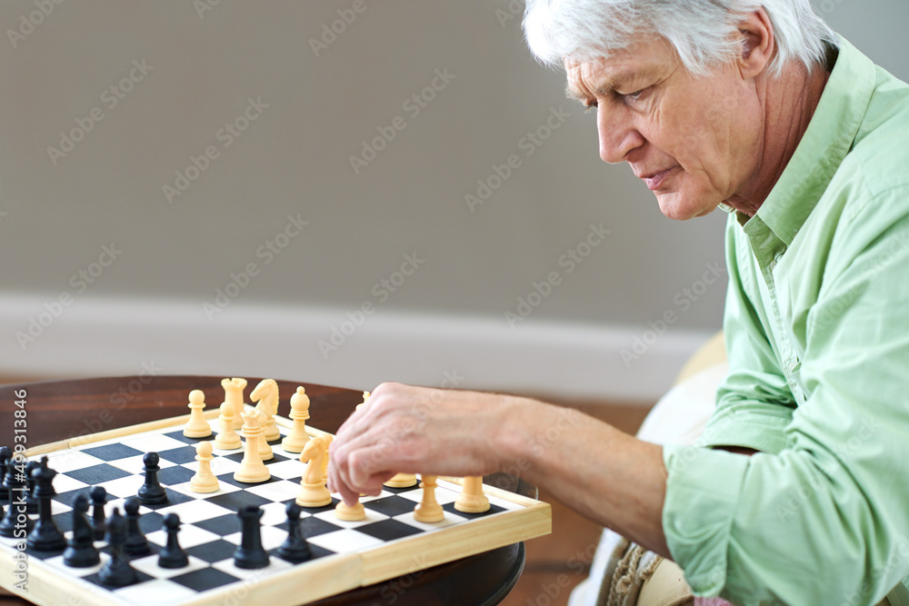 国际象棋刺激了他的思维。一位老人在家独自下棋的镜头。
