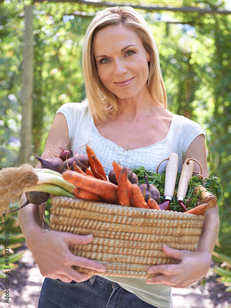 庆祝丰收。一个女人拿着一篮新鲜蔬菜。