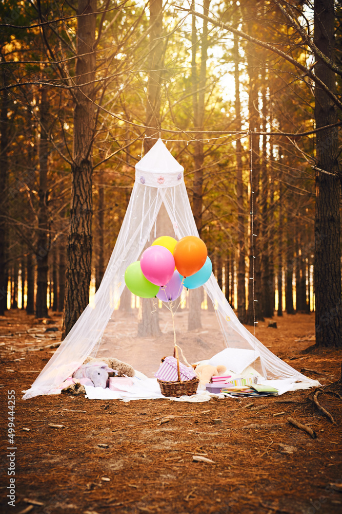 森林中的童话城堡。为儿童生日派对制作的帐篷的照片，里面装满了气球。