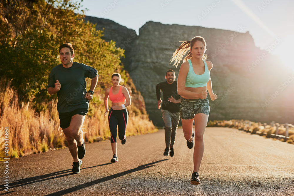 为你的日常锻炼增添一些乐趣。拍摄一个健身团体在乡村公路上跑步。