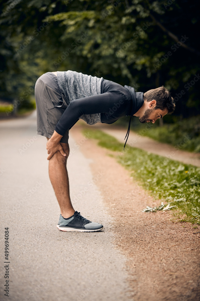 跑步前热身。一名运动型男子开始伸展运动的照片