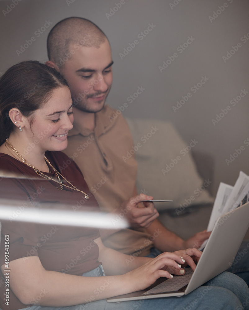 成年意味着要付账。一对年轻夫妇一起用笔记本电脑付账的镜头。