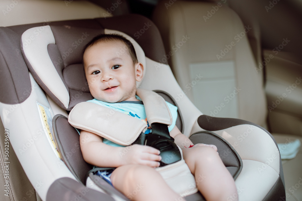 可爱的男婴在安全座椅上微笑。儿童运输安全概念。