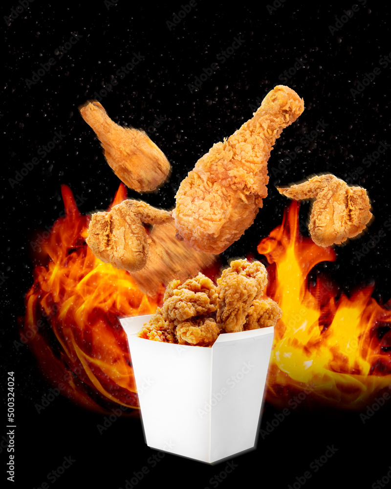 炸鸡在炽热的火焰背景下从纸桶里飞出来，辣炸鸡在b上