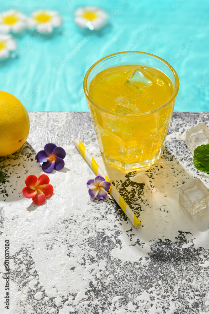 泳池边上的一杯新鲜柠檬汽水和鲜花