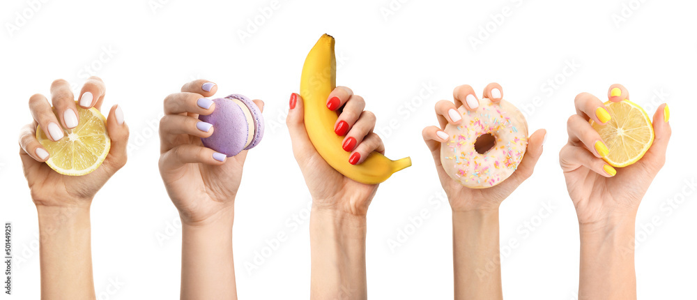 修指甲漂亮的女人的手在白底上拿着新鲜的水果和糖果