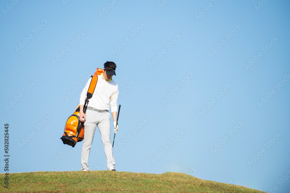 使用高尔夫球杆打高尔夫的亚洲职业高尔夫球手
