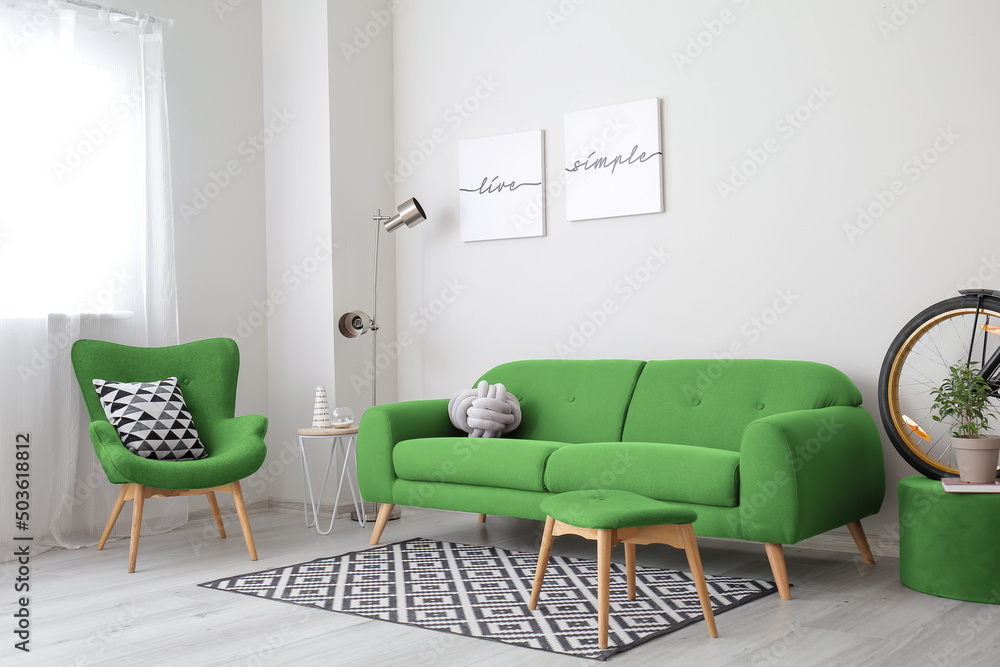 带绿色沙发和扶手椅的浅色客厅内部
