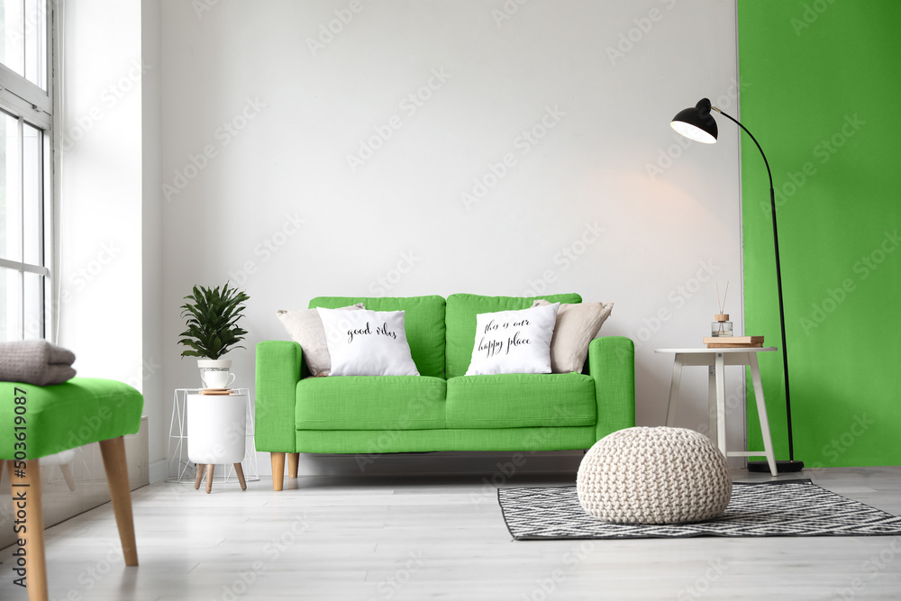 带绿色沙发、桌子、靠垫和灯的客厅内部