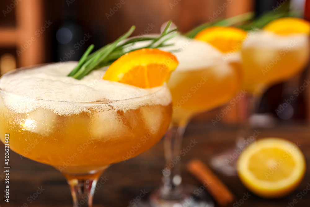 一杯美味的威士忌酸鸡尾酒，上面装饰着迷迭香树枝和一片橙子，关上