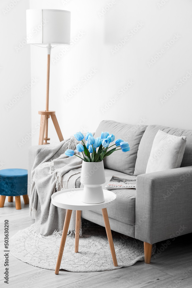带沙发和蓝色郁金香花瓶的浅色客厅内部