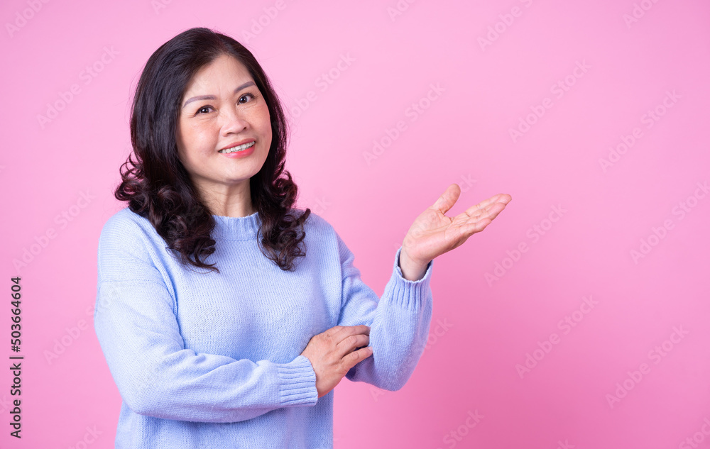 Portrait of middle aged Asian woman on pink background
