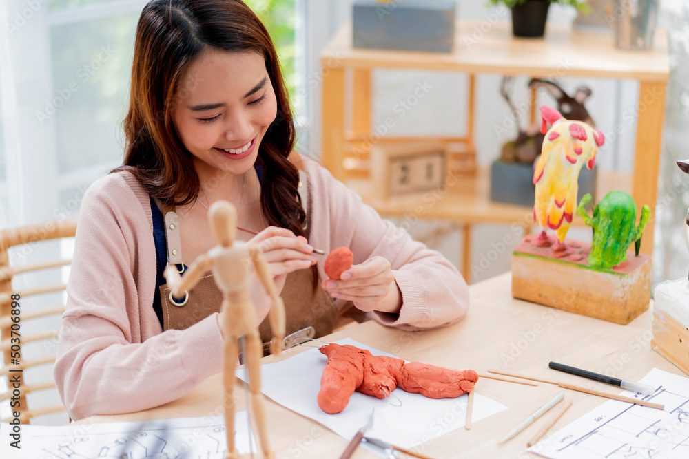 亚洲女性周末在家学习粘土雕塑在线课程，年轻人makin