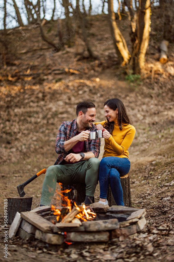 一对情侣在树林里露营时正在享受一杯茶。