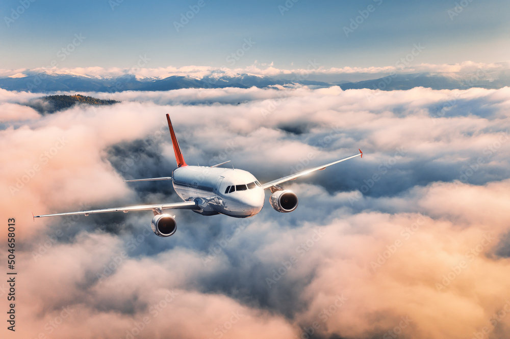 夏天日落时，飞机在云层上方飞行。有客机的风景，很美