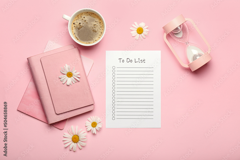 空白待办事项清单、笔记本、一杯咖啡、沙漏和彩色背景的洋甘菊花
