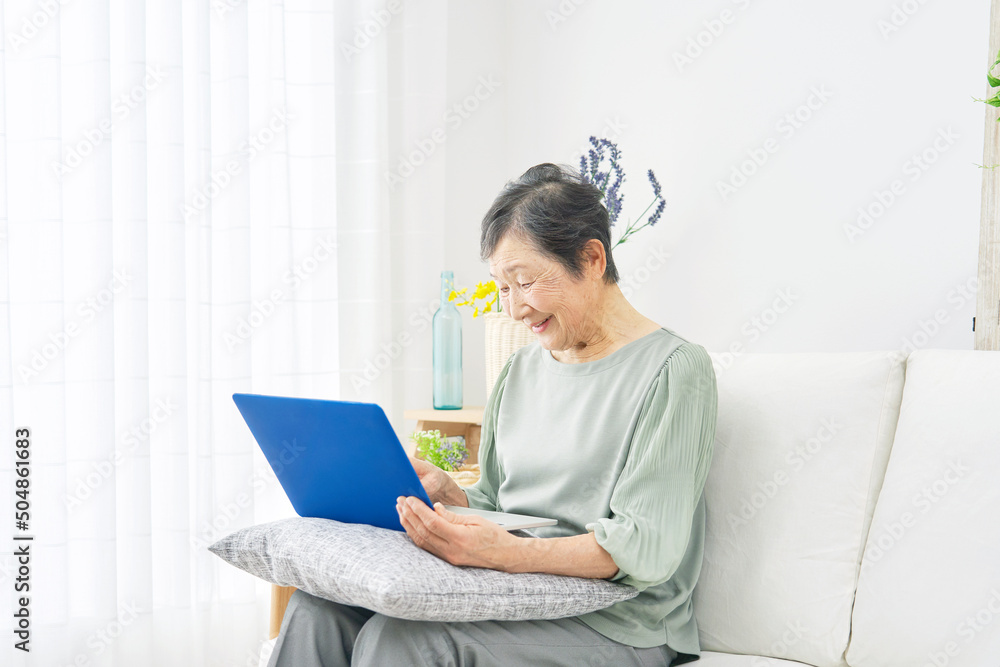 女性　高齢者　ノートパソコン　リビング