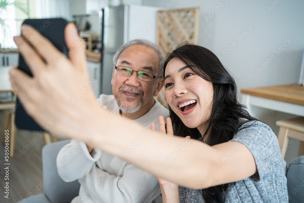 亚洲可爱的家庭，年幼的女儿与年长的父亲用手机自拍