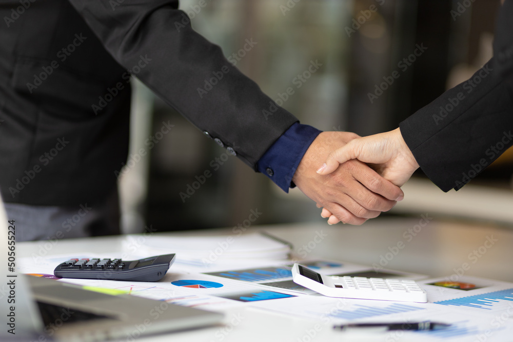 握手。商业人士在商业规划分析会议后与商业伙伴握手
