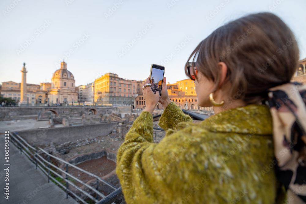 快乐的女人在罗马旅行时拍摄罗马论坛的照片。穿着外套和
1096555110,一名女子牵着狗在罗马著名的中央大街上散步，在手机上拍照，享受o