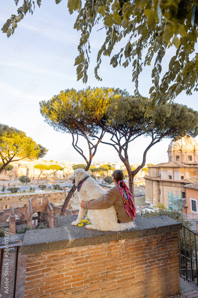 一个女人和一只狗坐在一起，从罗马市中心欣赏美景。考克