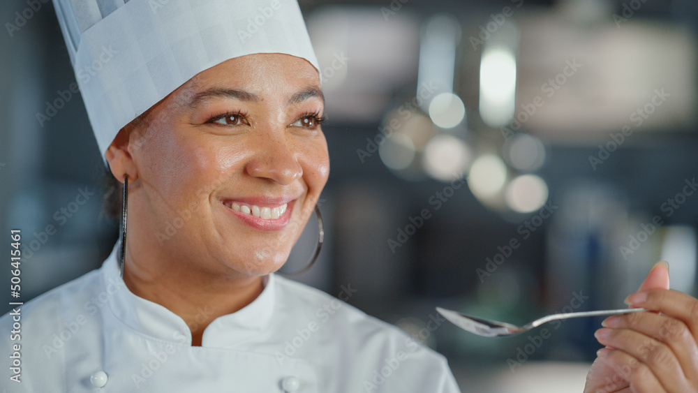 餐厅厨房：黑人女厨师准备菜肴、品尝食物并享受美食的肖像。教授