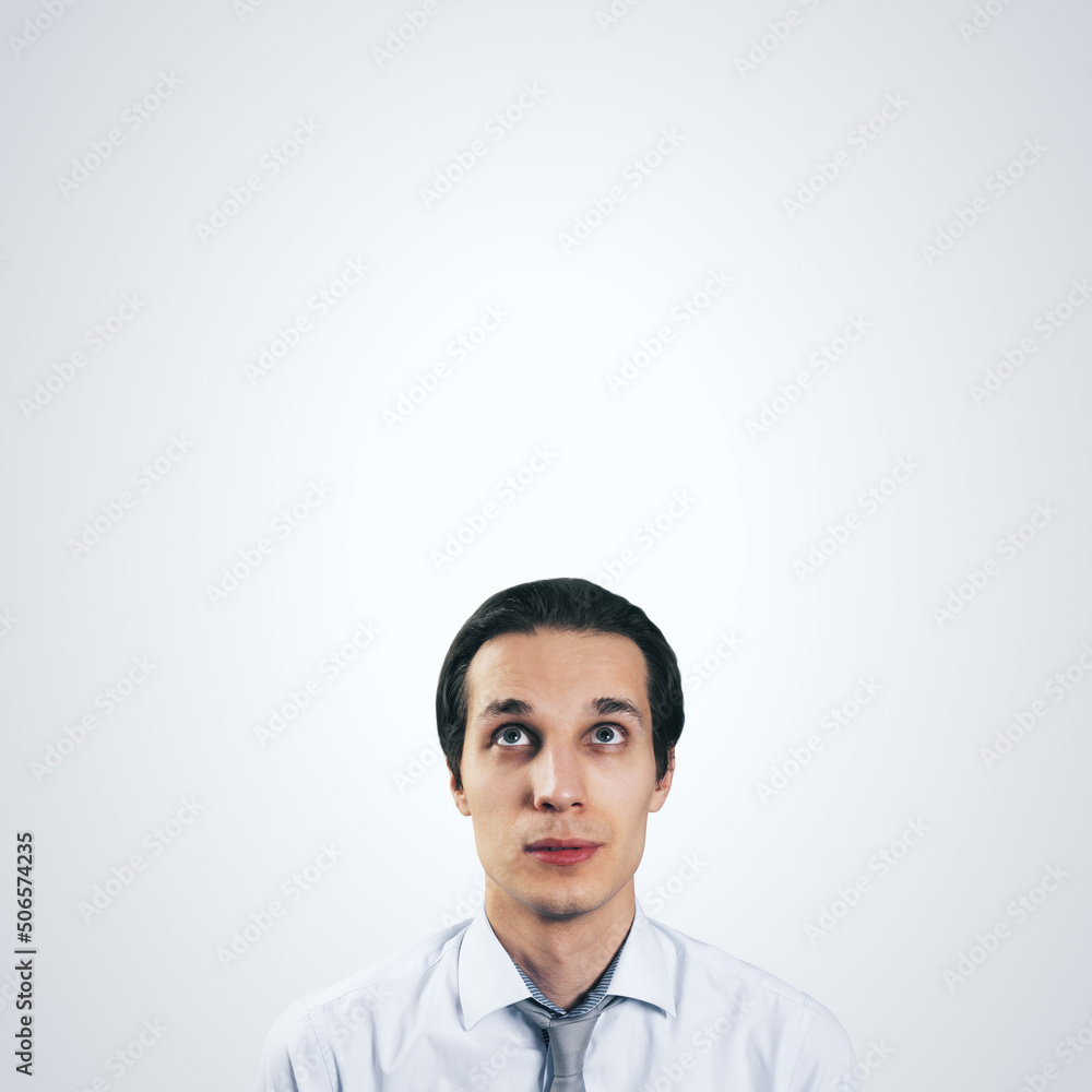 Man looking up in white shirt and tie isolated on blank light grey background with empty space for y