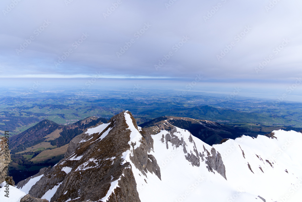 Panoramic landscape with rocks, hills and Rhine Valley in the background seen from Säntis peak at Al