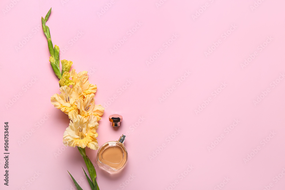 Beautiful gladiolus flowers and bottle of perfume on color background