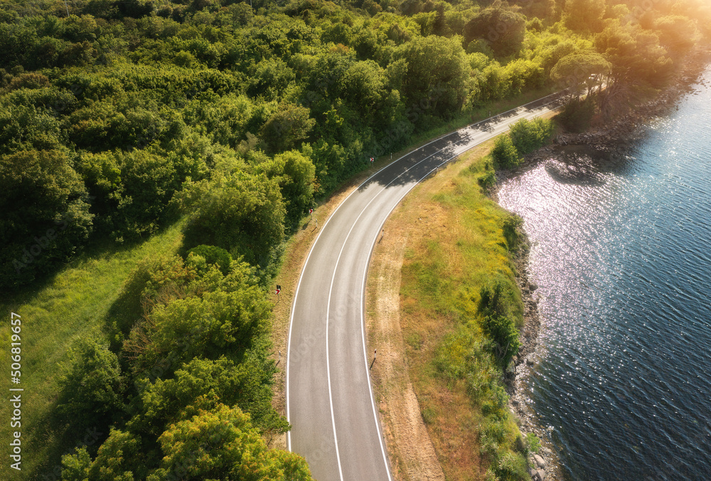 Aerial view of road near blue sea, forest at sunset in summer. Travel in Croatia. Top view of beauti