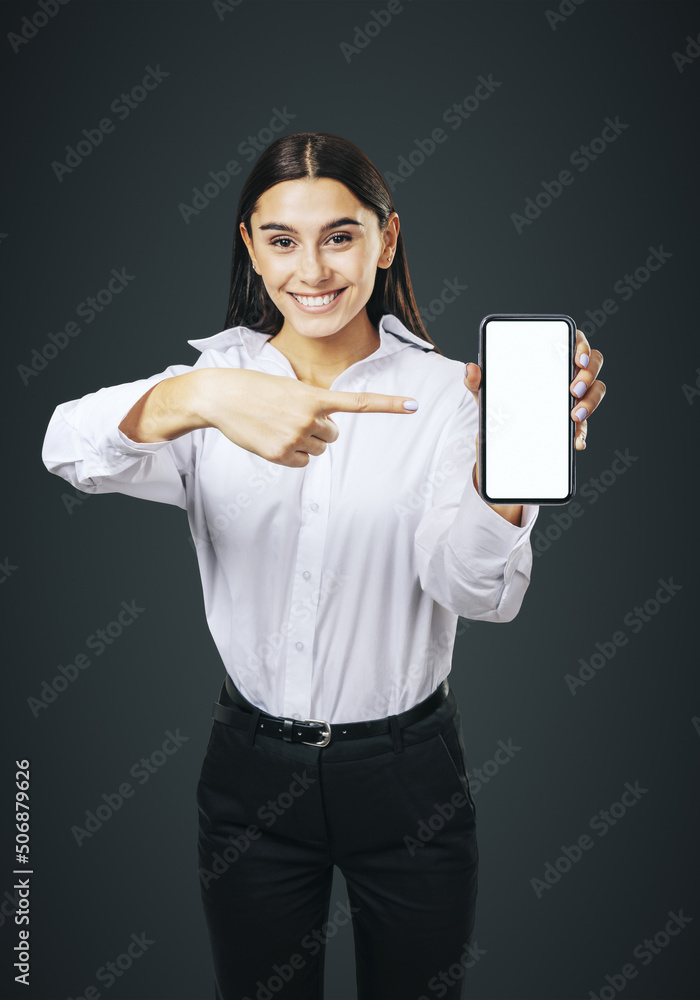 移动应用程序概念，穿着白衬衫的快乐女孩展示白色空白的现代智能手机