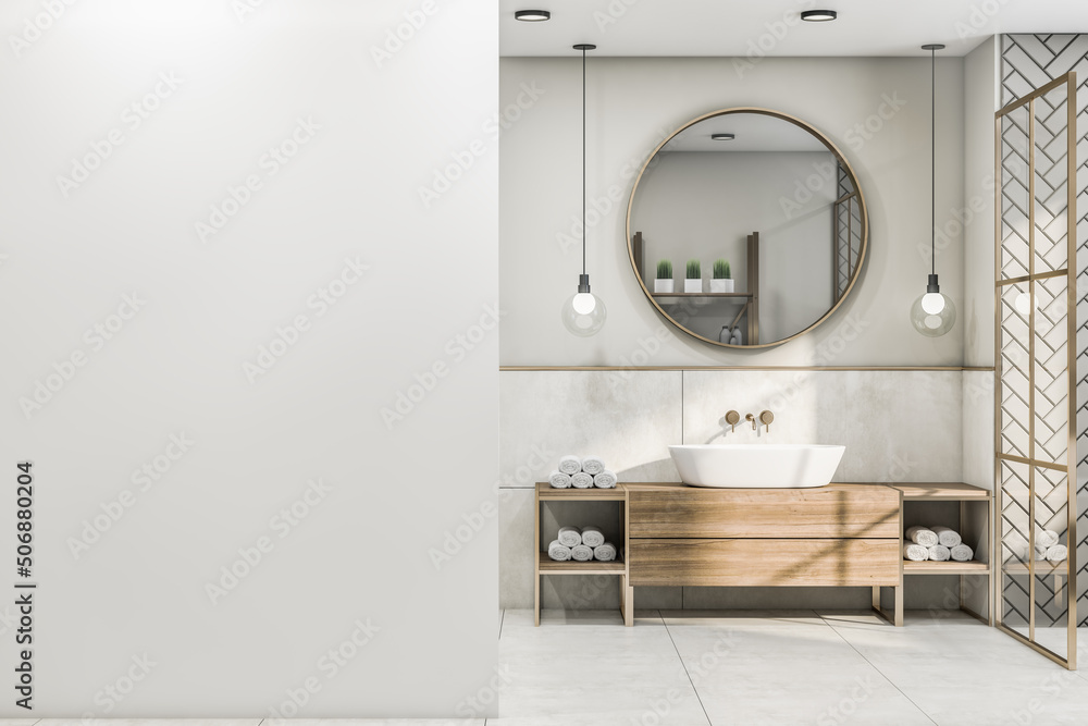 时尚浴室的空白白墙正视图，配有圆形木框镜子和现代灯泡