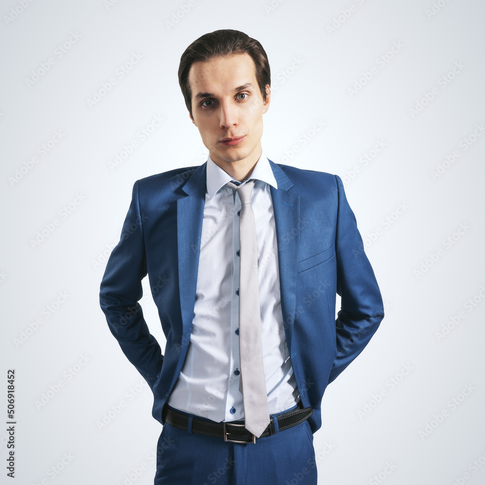 浅背景下，穿着蓝色西装，打着灰色领带的年轻成功商人，特写