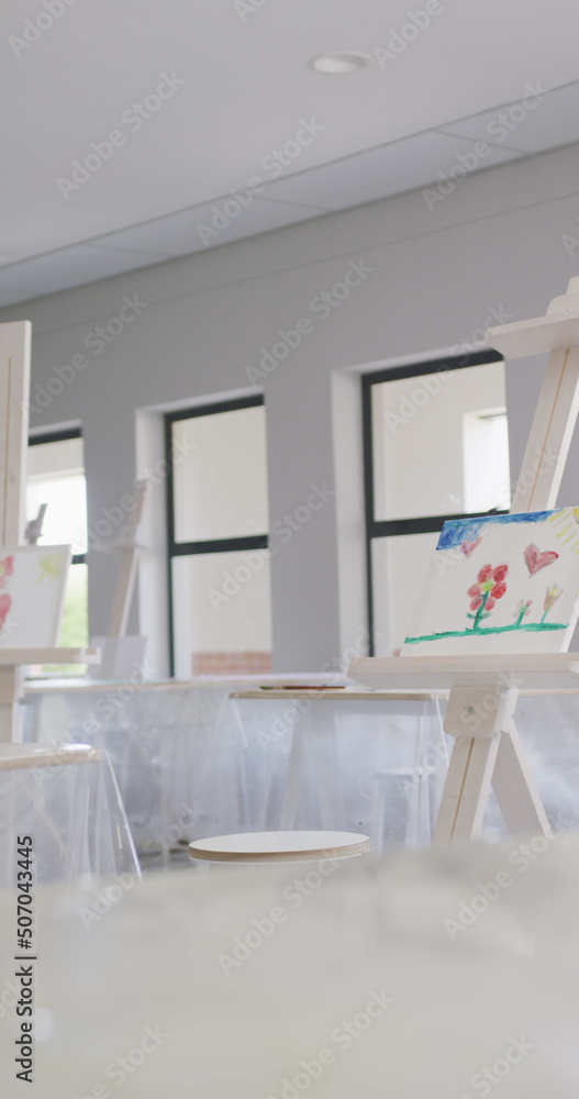 空荡荡的白色绘画教室的垂直图像，配有绘画设备和画架