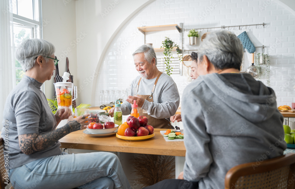 一群亚洲老年人朋友为朋友制作果汁，让他们在厨房里喝。colorful fr