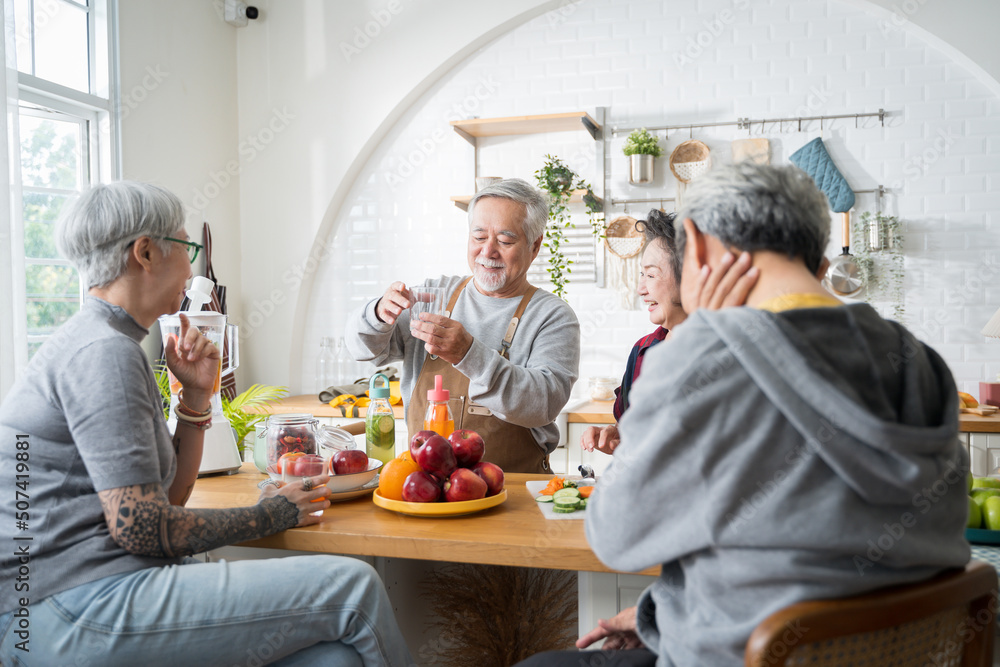 一群亚洲老年人朋友为朋友们制作果汁，让他们在厨房里喝。colorful fr