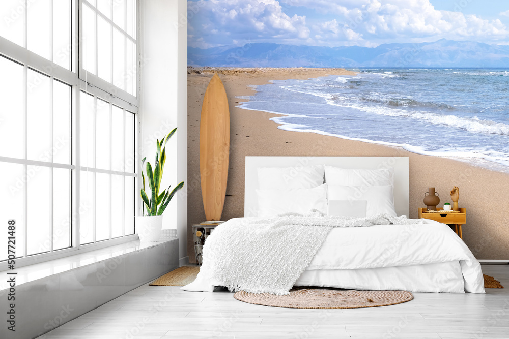 墙上印有海滩图案的大床和冲浪板