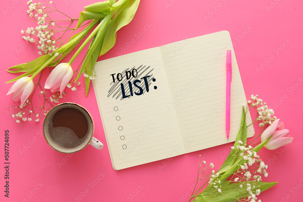 带空白待办事项列表的笔记本，粉红色背景上有鲜花和咖啡