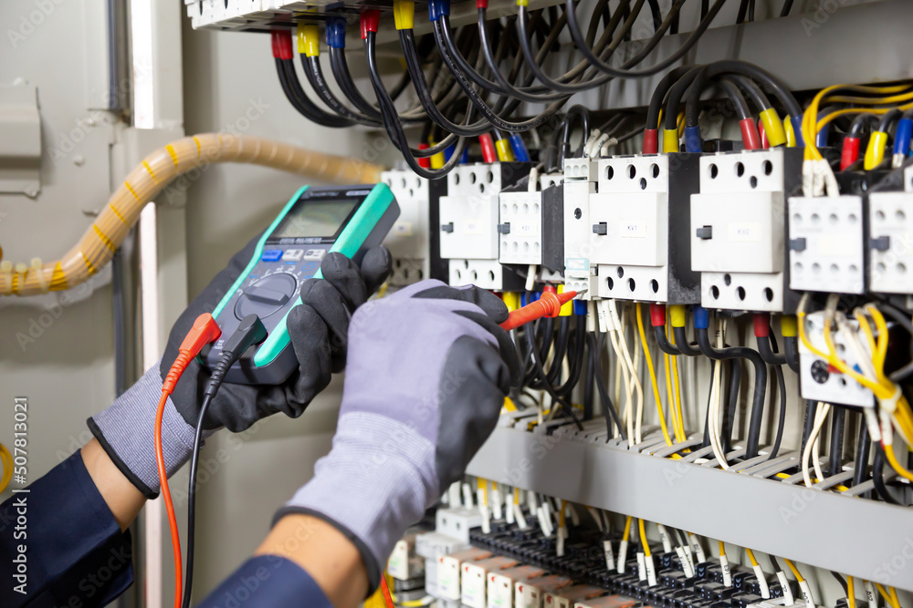 电工工程师测试继电保护系统上的电气装置和电线。调整
