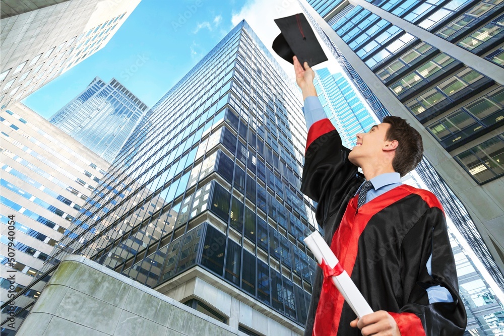 Man graduation in hat and stand on cityscape, education concept