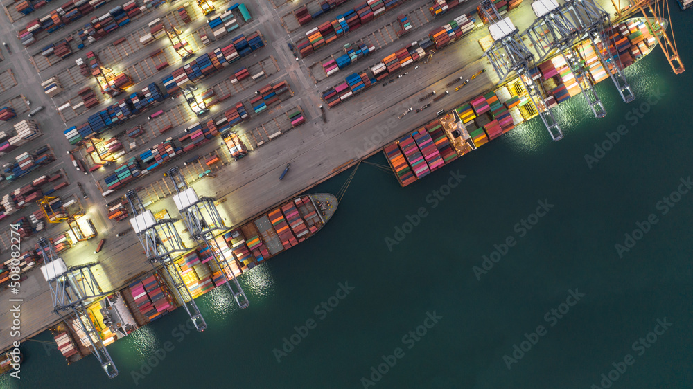 在夜间码头海港工作的鸟瞰集装箱船，全球商业公司进口-出口