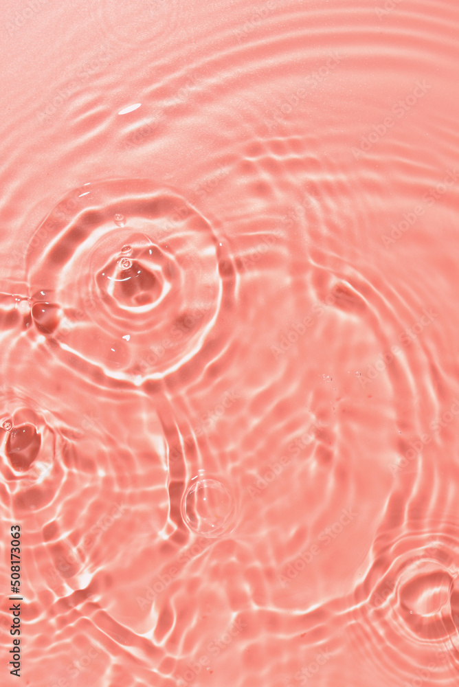 粉红色背景上有波纹的水的纹理，特写