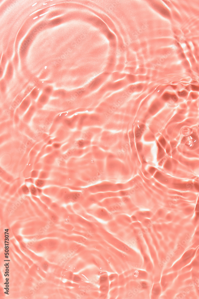 粉红色背景上有波纹的水的纹理，特写
