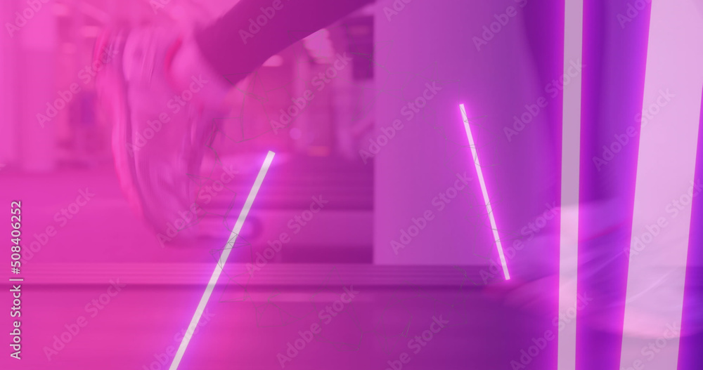 运动员在健身房跑步机上跑步时亮起粉红色灯光的图像