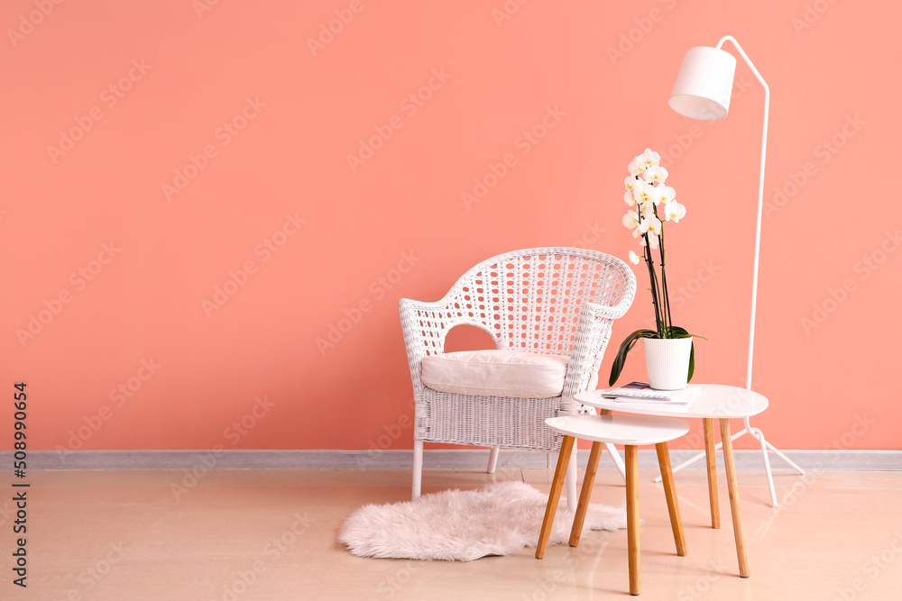 房间内部靠近彩色墙壁的柳条椅、兰花花桌子和落地灯