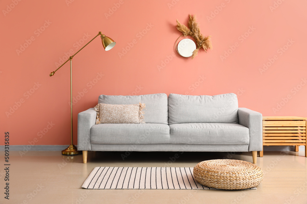 粉色墙壁附近舒适的沙发和时尚的灯