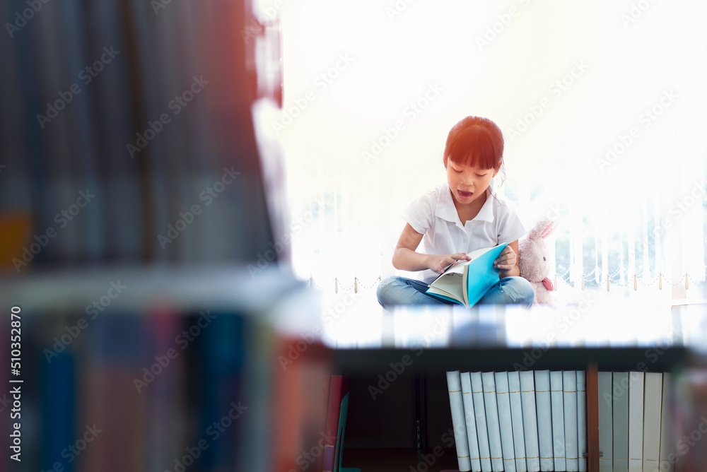 亚洲儿童女学生在图书馆看书