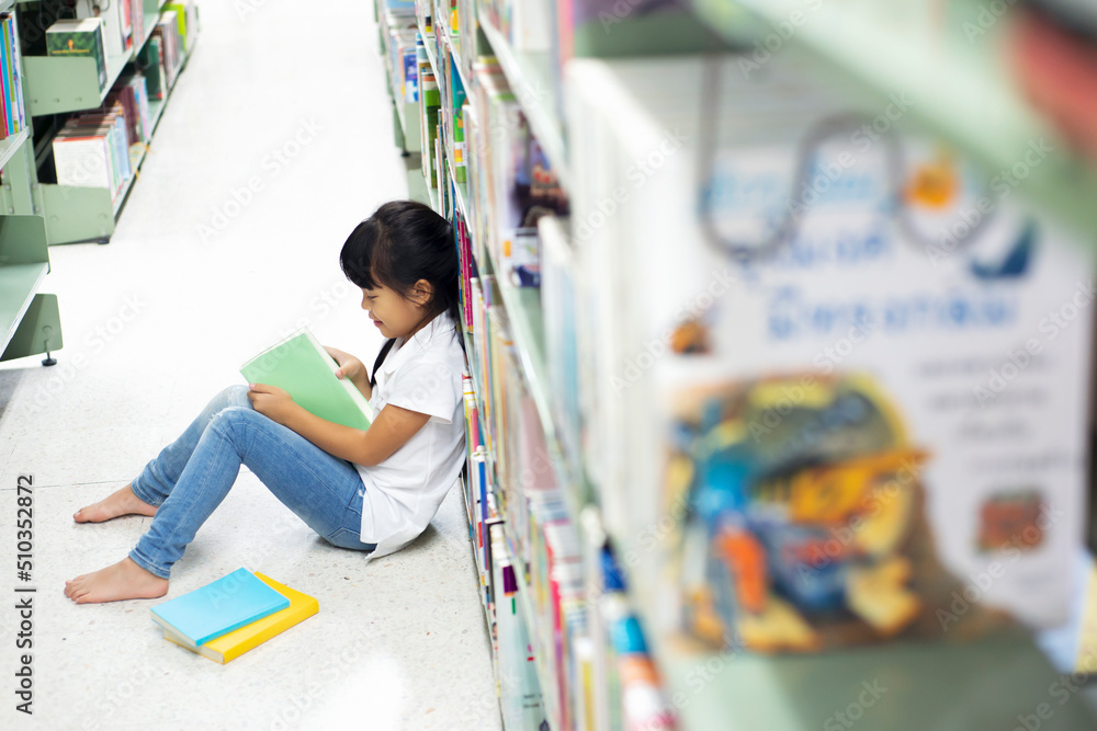 Asian children schoolgirl reading books in library